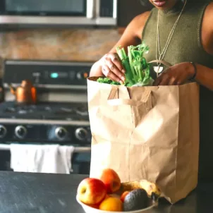 Woman unpacking her grocery bag of the fruits and vegetables