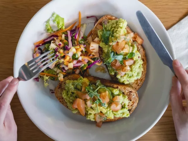 Man cutting into a plant-based diet meal on toast