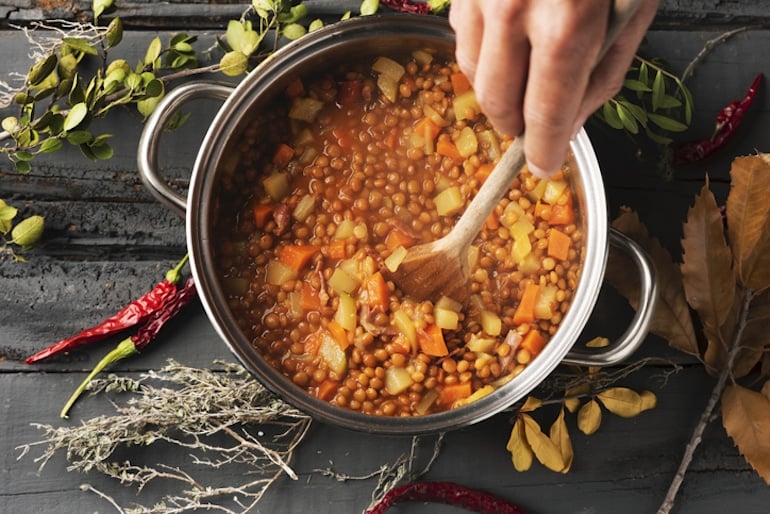 Man mixing a plant-based lentil stew for plant protein and other nutrients