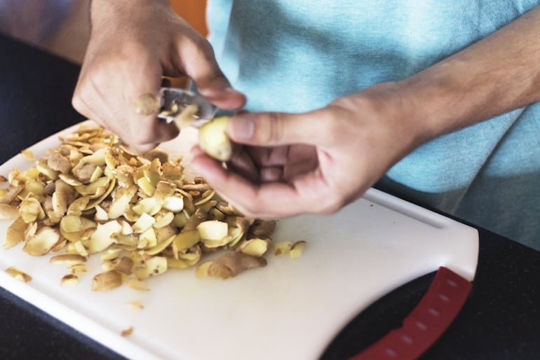 Man peeling potatoes, one of the longest-lasting produce items