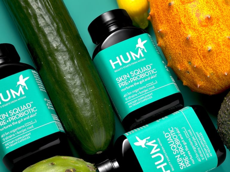 HUM Skin Squad Pre and Probiotic for clear skin, next to cucumber and other raw ingredients