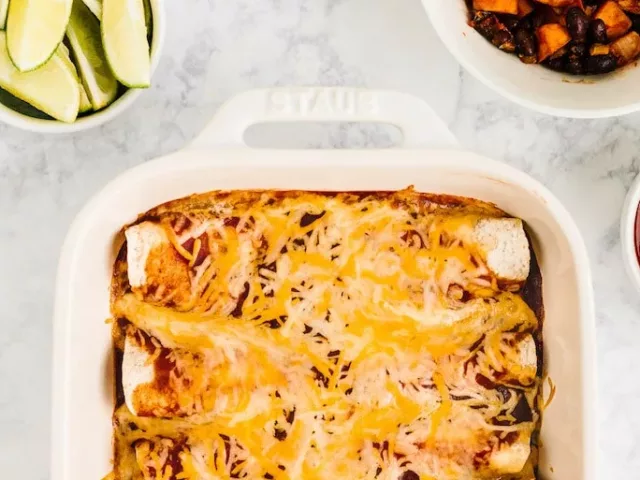 Cooked Sweet Potato Black Bean enchiladas next to limes