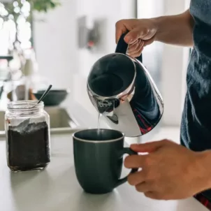 Man pouring coffee at home, but too much caffeine can weaken immune function