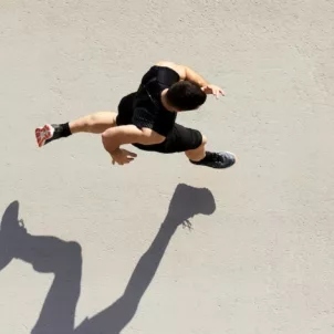 Overhead shot of man running with shadow, supported by boosting his levels of nitric oxide for respiratory health