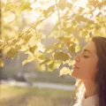 Woman at park under trees in sunlight to get immunity-boosting vitamin D