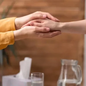 Therapist holding client's hand during a successful talk therapy session