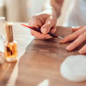 Woman removing her gel manicure at home and pushing her cuticles