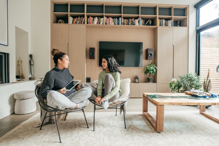 Two female friends socializing at home