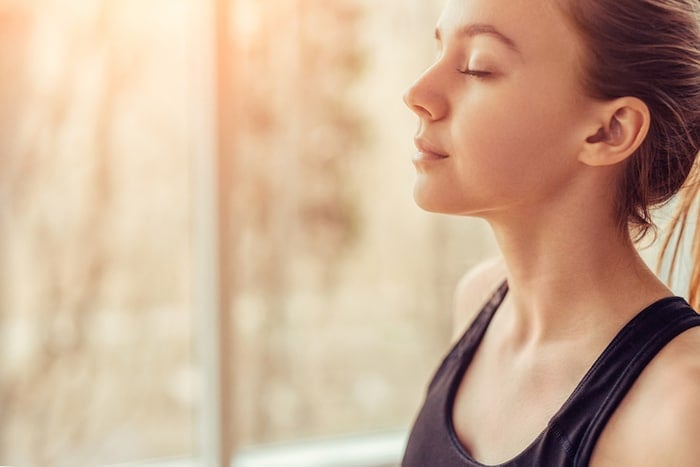 Young woman doing breathing exercises for healthy lungs