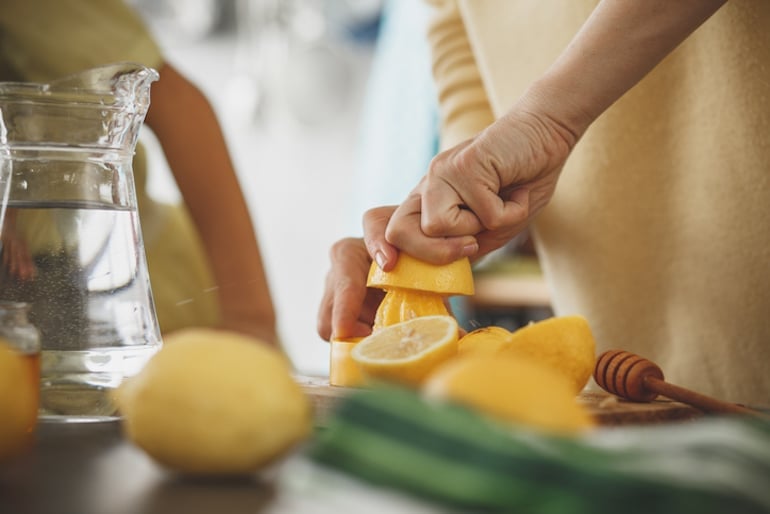 Woman juicing a lemon which is a stress-reducing food