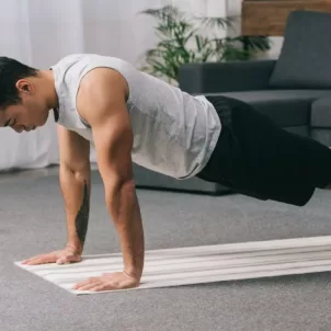 Man in plank pose on a yoga mat at home