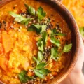 Woman holding WFPB diet meal of vegan curry