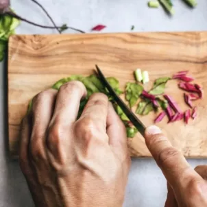 Man chopping kale, one of the foods to eat for weight loss on the sirtfood diet