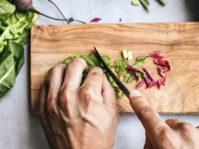 Man chopping kale, one of the foods to eat for weight loss on the sirtfood diet