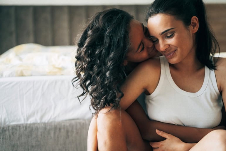 Lesbian couple fostering intimacy in the bedroom as one of the benefits of orgasm