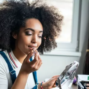 Woman applying makeup at home