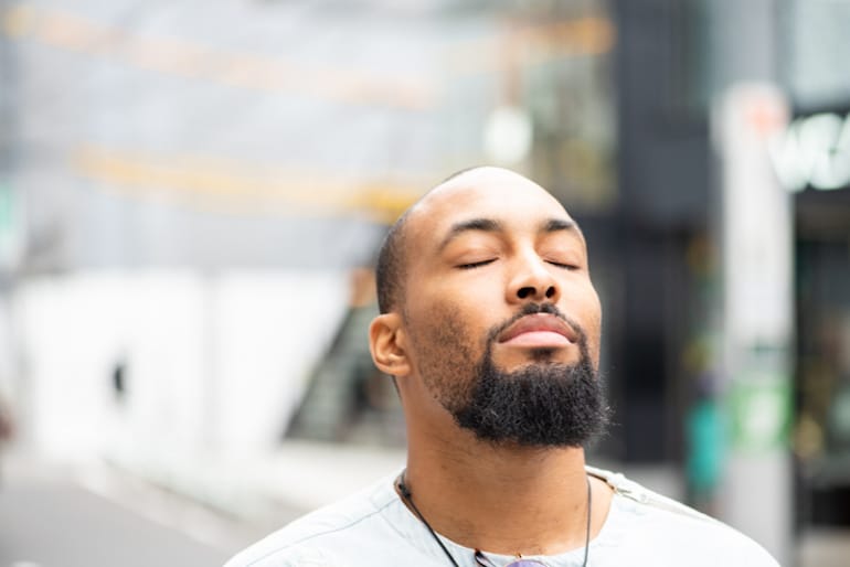 Man with eyes closed outdoors, positive and hopeful with the power of visualization