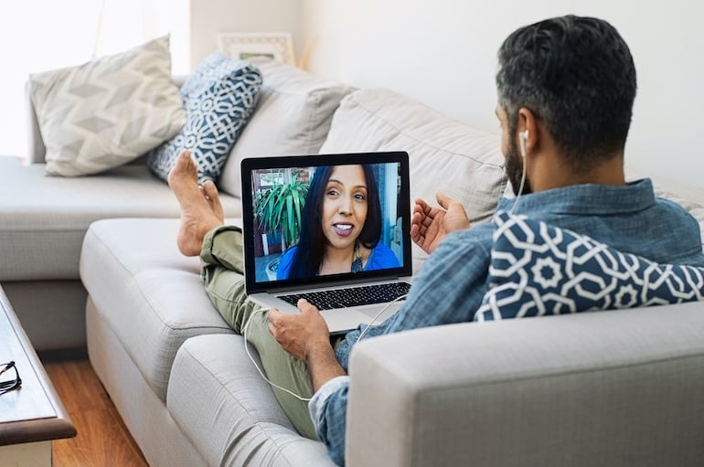 Man video chatting with a woman on his laptop, trying to have a successful virtual dating experience in quarantine