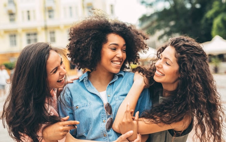 Three girlfriends with different hair types having fun, illustrating that scalp massages are good for all hair types