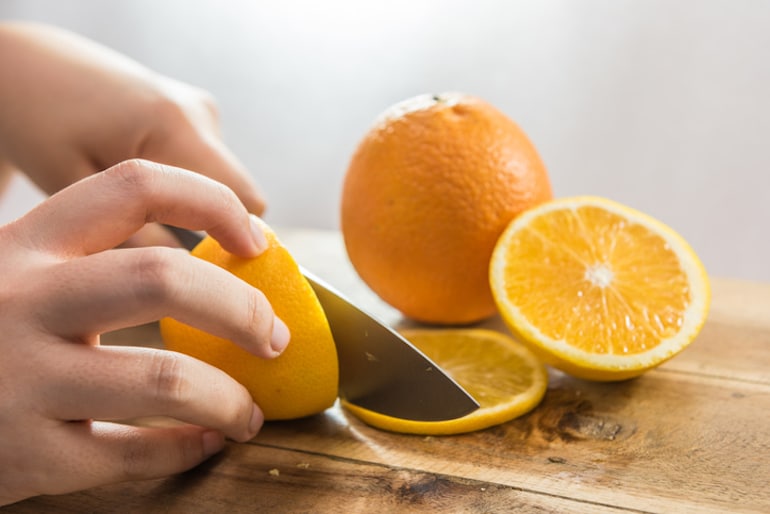 Slicing an orange, one of the best chromium foods