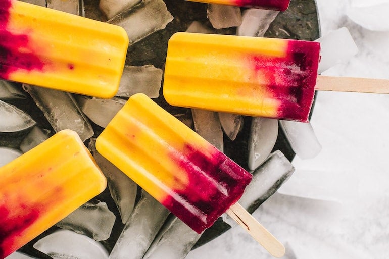 Fruit popsicles for beauty with mango and raspberry on ice