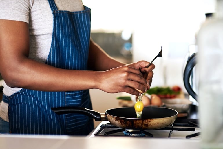 Man cooking eggs for a natural source of energy and satiety