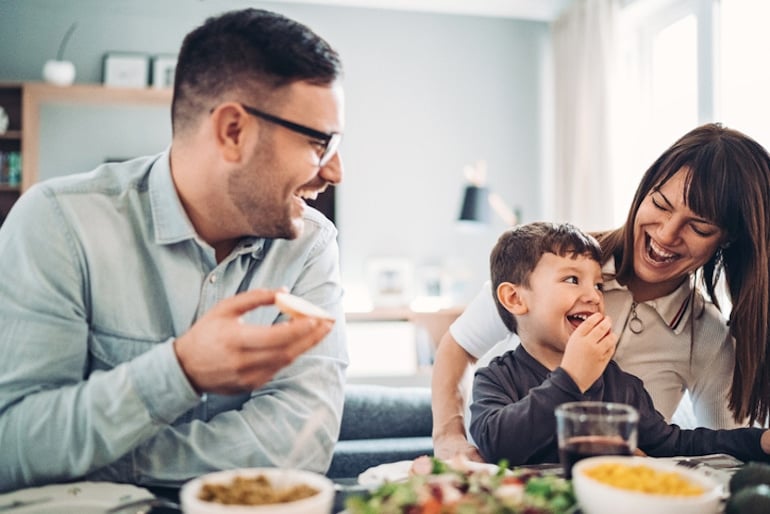 Couple with toddler son enjoying their dinner by eating mindfully, slowing down and enjoying their company