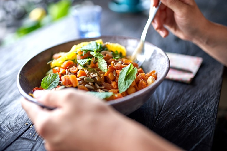 Person eating vegetarian meal which may lack vitamin B12 and other essential micronutrients