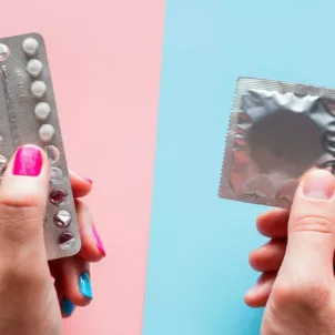 Woman's hand holding pack of birth control pills on pink background and man's hand holding a condom on blue background