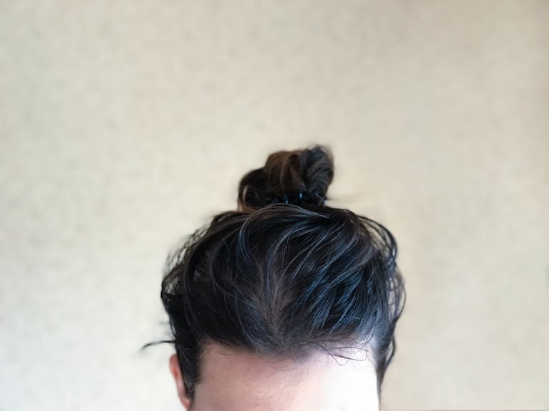 Girl with greasy hair up in a bun