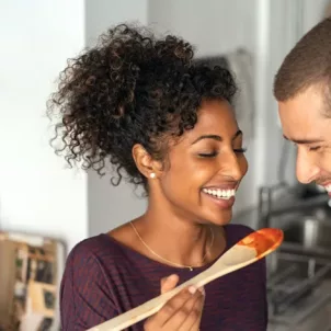 Young couple tasting dinner during prep, enjoying their time together as a component of mindful eating