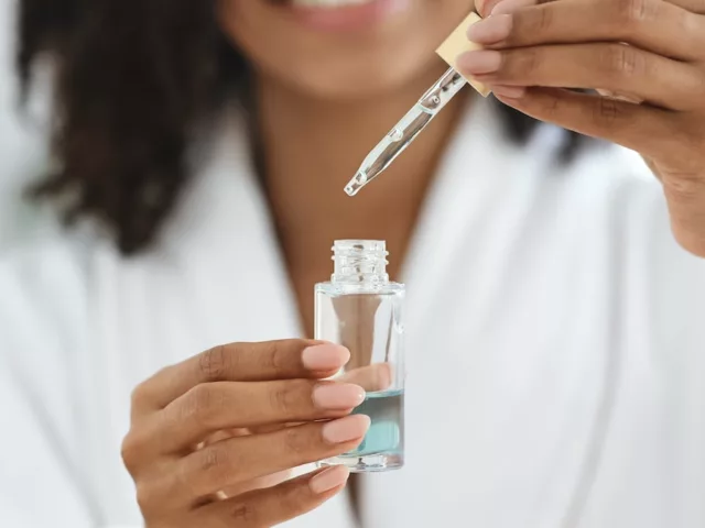 Woman holding a face serum to target her skin concerns