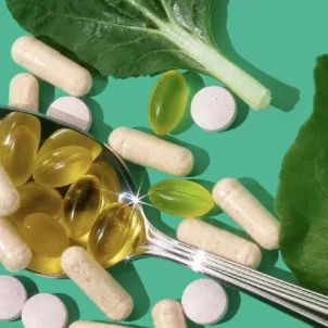 Personalized HUM vitamins and supplements on a spoon next to leaves on a bright green background, to demonstrate how to find the best vitamins for you