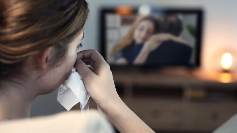 Woman experiencing the health benefits of crying while watching a sad film