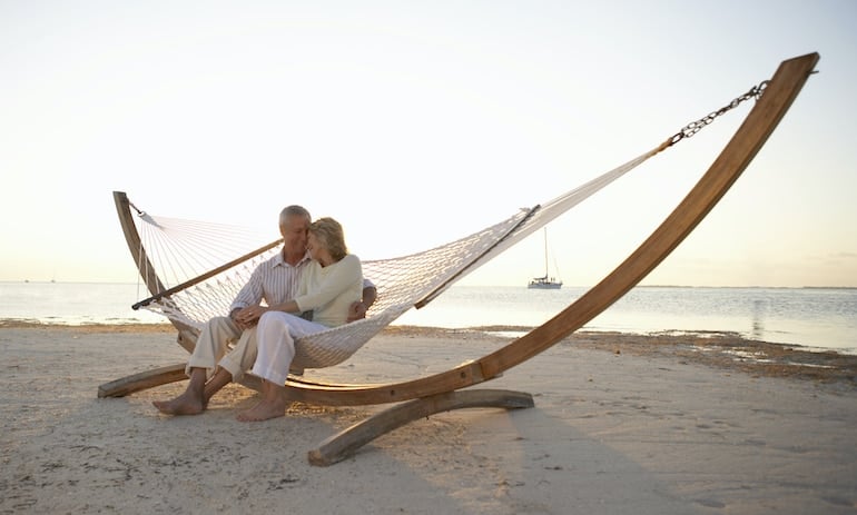 Mature couple in love and happy on hammock on the beach, illustrating that your sex life is one of the top things that get better with age