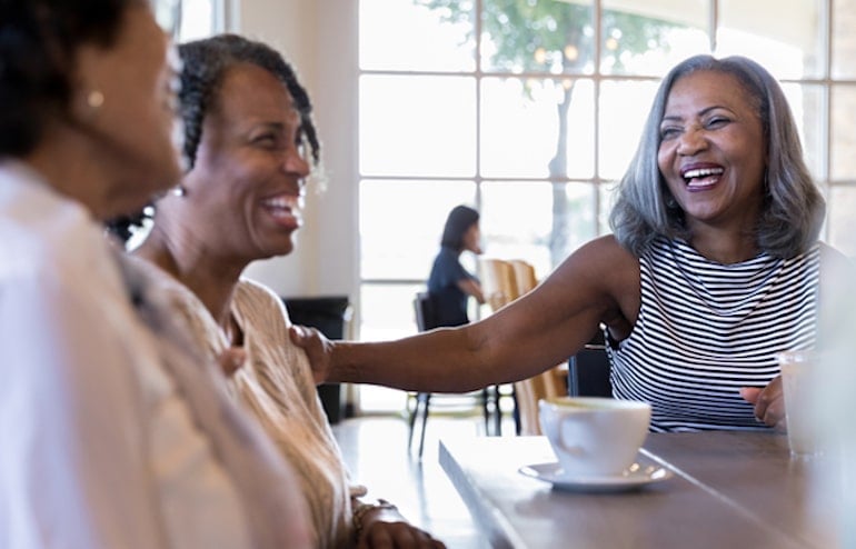 Group of female senior citizens laughing at cafe