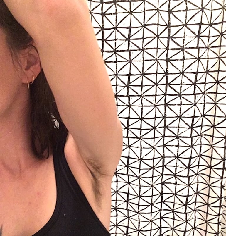 Woman embracing body hair by not shaving her underarms