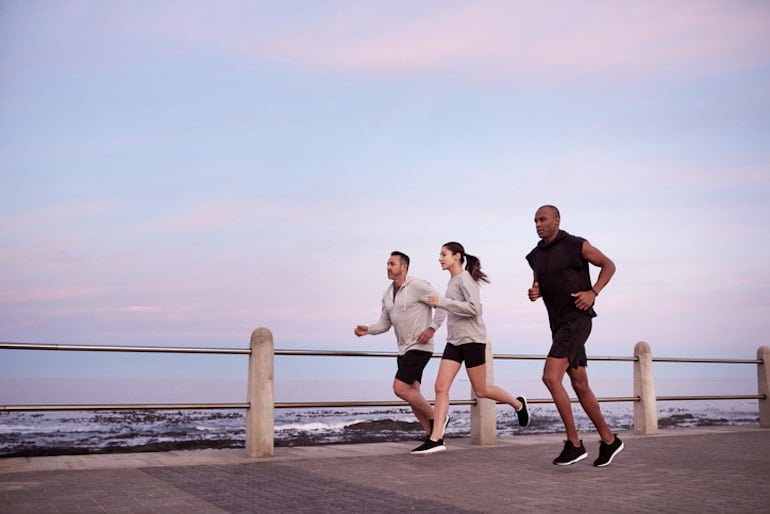 Friends running on the boardwalk as a social, easy way to detox your body naturally