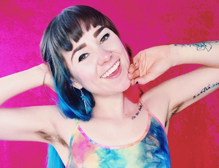 Kactus Kutie posing with hands behind head to show her armpit hair and illustrate embracing body hair for women