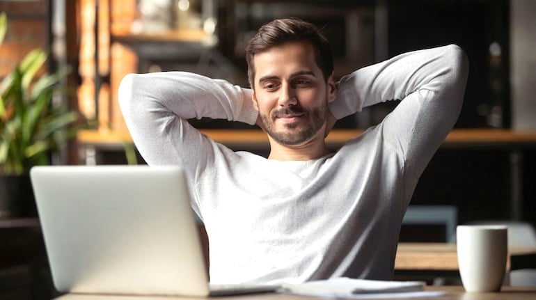 Serene man in front of laptop, happy and relaxed from adopting the inbox zero method