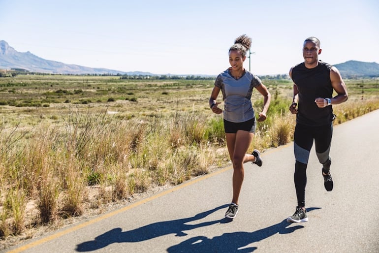 Man and woman running in nature, to exercise both their brains and bodies for many health benefits