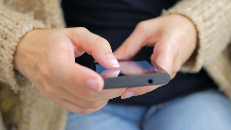 Woman scrolling on smartphone to illustrate how the internet affects the brain