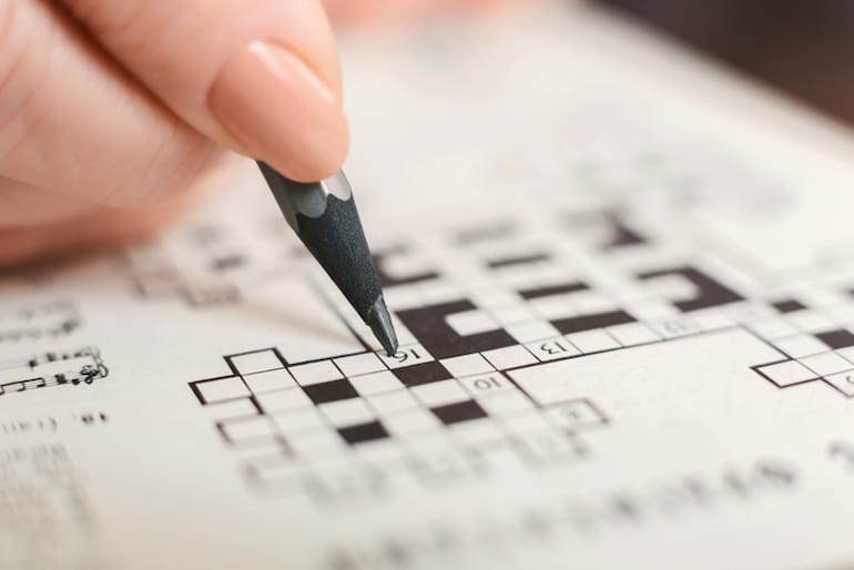 Woman doing a crossword puzzle, one of the best ways to exercise your mind