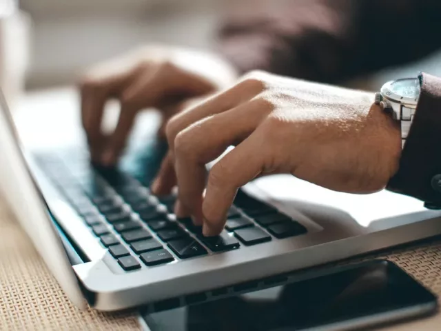 Man's hands at work on laptop, implementing the inbox zero method