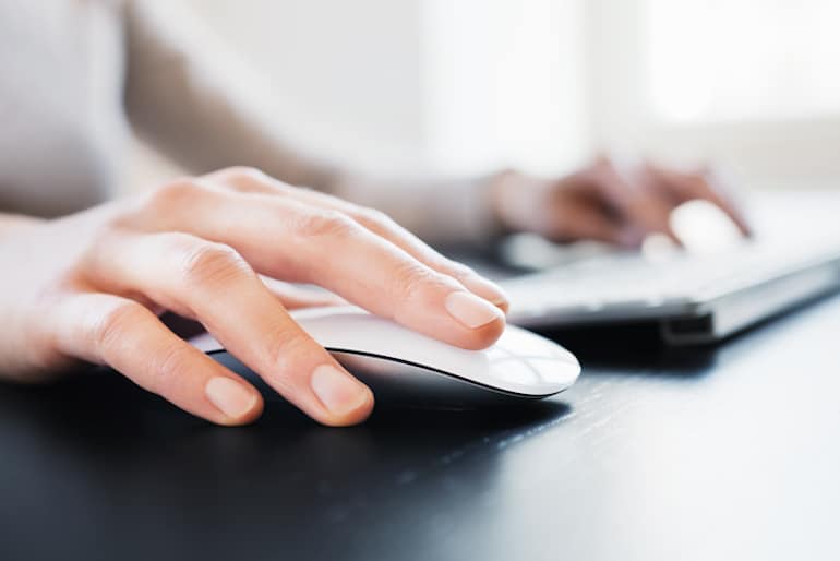 Woman clicking wireless mouse; digital wellness concept