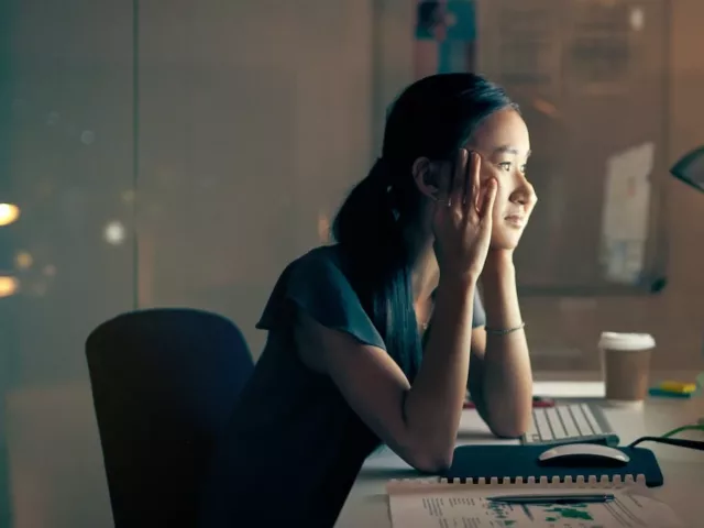 Woman staring at computer late at night, illustrating how the internet is changing your brain