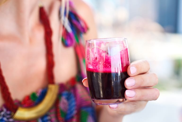 Woman holding glass of beet juice, which might change her urine color