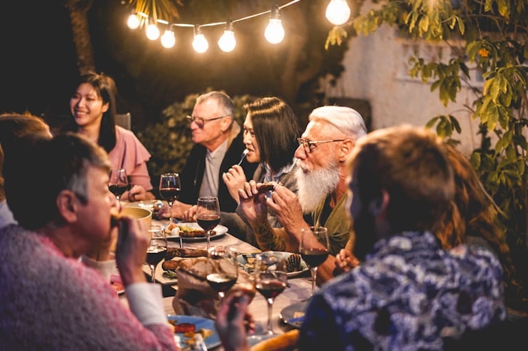 Group dinner outdoors, illustrating concept of different backgrounds having different makers of bio-individuality and nutrition