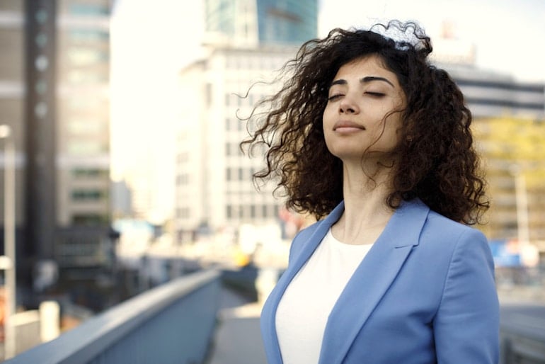 Woman taking a break from work to get air outside, which is often polluted with toxins