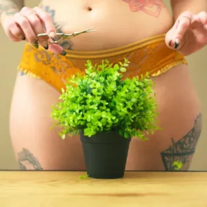 Woman in lingerie with plant in front of her vagina, illustrating embracing body hair for women